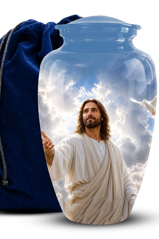 A clear glass cremation urn with a printed image of Jesus Christ and clouds, shown next to a dark blue velvet drawstring bag on a white background.