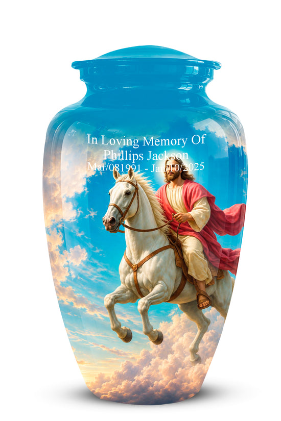 A personalized blue glass cremation urn with a lid, featuring a printed graphic of a man in a red cloak riding a white horse through the clouds. White text on the front reads 'In Loving Memory Of Phillips Jackson' with birth and death dates.