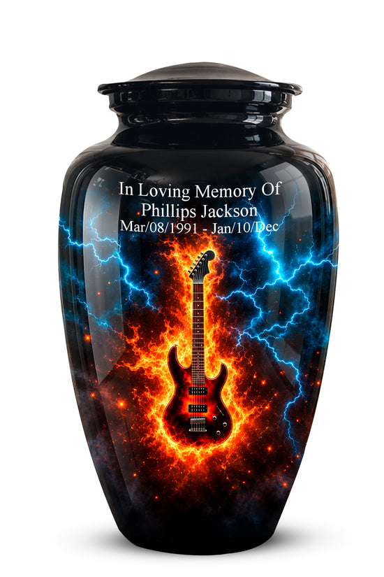 A glossy black memorial urn with a lid, featuring a printed design of a red electric guitar surrounded by blue lightning and orange flames. White text on the front reads 'In Loving Memory Of Phillip Jackson' with dates below.