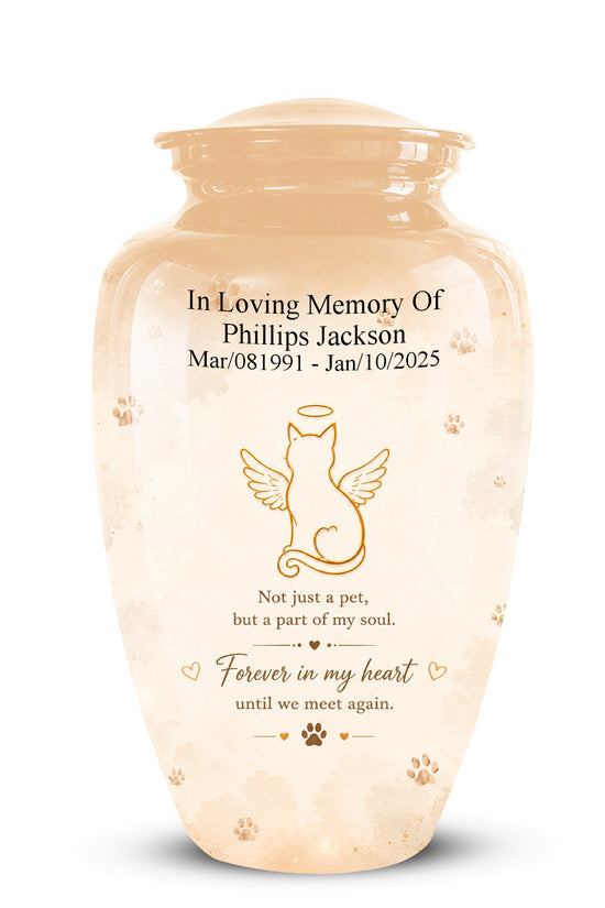 A cremation urn with a beige and cream marbled finish, featuring a gold engraved illustration of a winged cat and personalized memorial text for a pet.