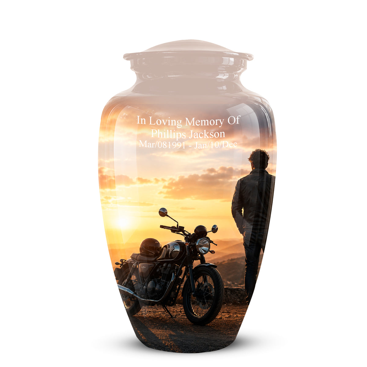 A personalized glass urn with a lid, featuring a printed sunset landscape design of a man and a motorcycle. The front of the urn has white text reading 'In Loving Memory Of Phillips Jackson' with dates below, shown on a clean white background.