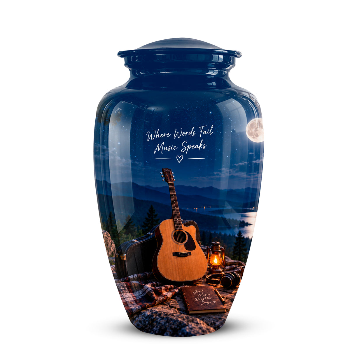A glossy blue ceramic cremation urn featuring a scenic landscape print of a mountain lake at night with an acoustic guitar, lantern, and blanket. The urn has a matching blue lid and white script text that reads 'Where Wounds Heal Music Speaks'.