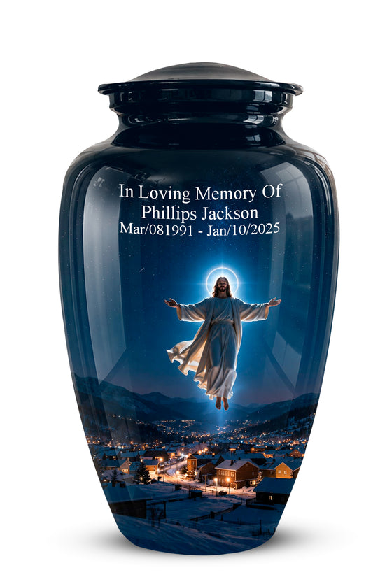 A glossy dark blue memorial urn with a lid, featuring a printed image of Jesus floating above a snowy mountain town at night. White personalized text on the front reads 'In Loving Memory Of Phillips Jackson Mar/08/1991 - Jan/10/2025'.
