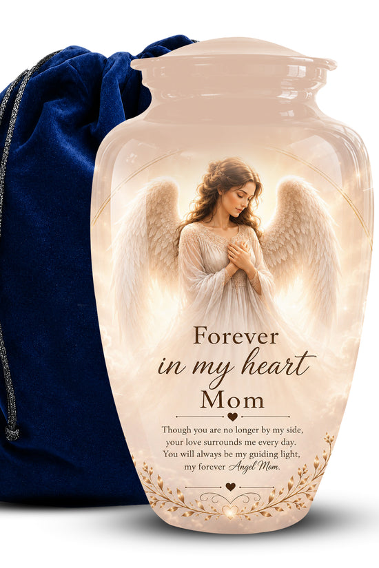 A cremation urn vase with a printed angel portrait and the text 'Forever in my heart Mom' on a white background, shown with a dark blue velvet drawstring bag behind it.