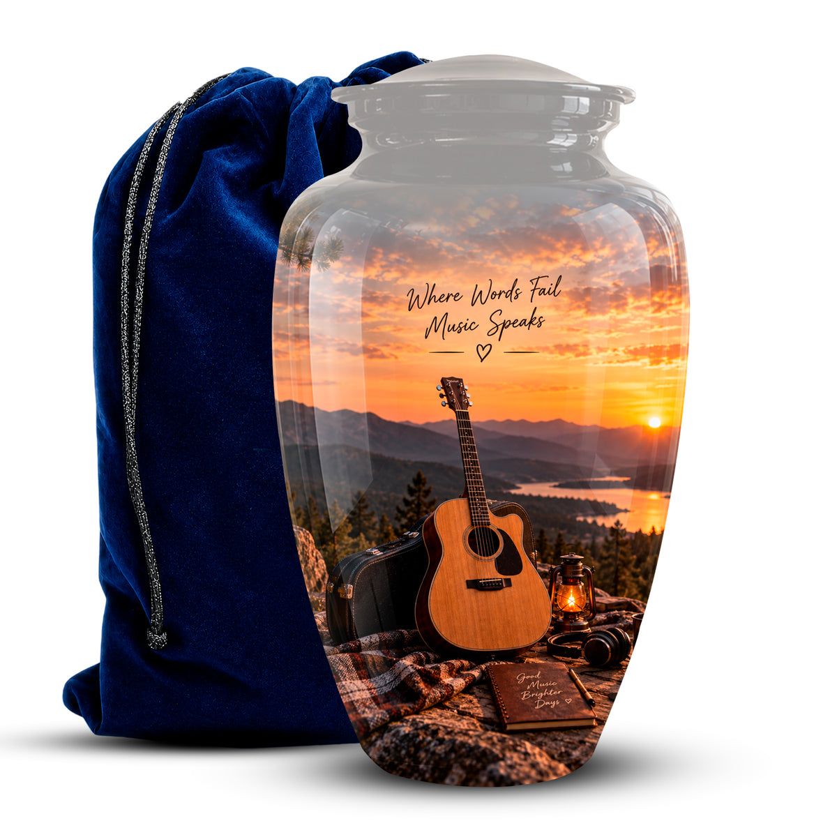 A clear glass urn-shaped vase with a printed scenic sunset design showing an acoustic guitar, mountains, lake, and the phrase 'Where Words Fail Music Speaks,' displayed next to a dark blue velvet drawstring bag on a white background.