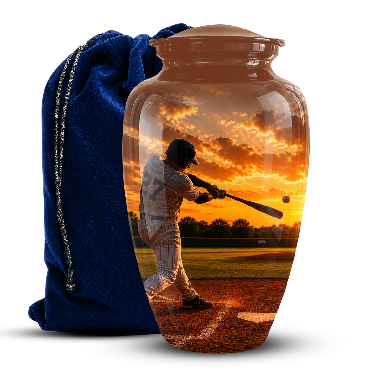 A clear glass urn-shaped vase with a lid, printed with a baseball player at sunset, shown next to a blue velvet drawstring bag on a white background.