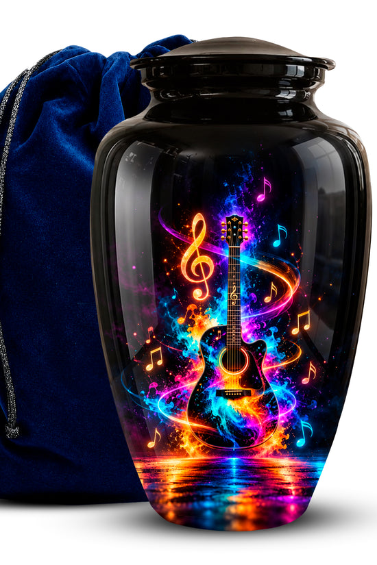 A glossy black urn-shaped vase with a colorful neon guitar and musical note design on the front, shown beside a dark blue velvet drawstring bag on a white background.