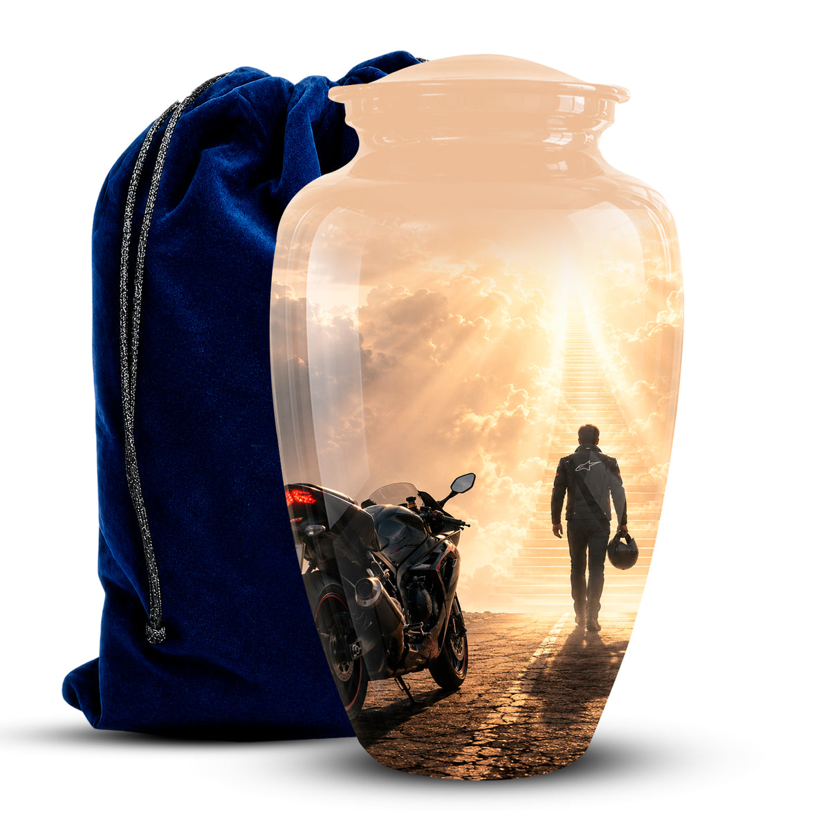 A clear glass cremation urn with a printed scenic design of a motorcycle and a person walking toward a bright sunset, shown next to a dark blue velvet drawstring bag on a white background.