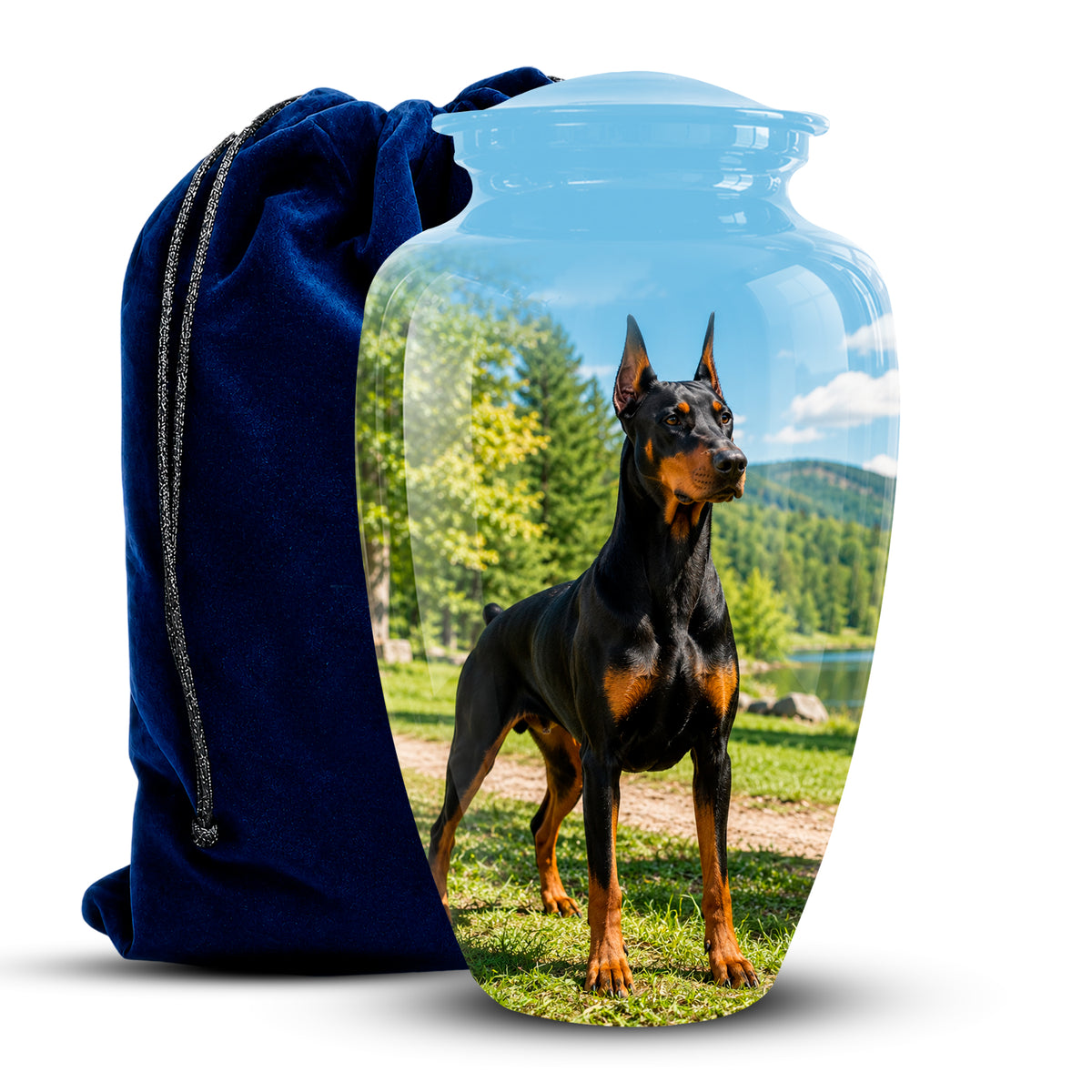 A clear glass pet urn with a custom printed photo of a black and tan Doberman on the front, shown next to a dark blue velvet drawstring bag on a white background.