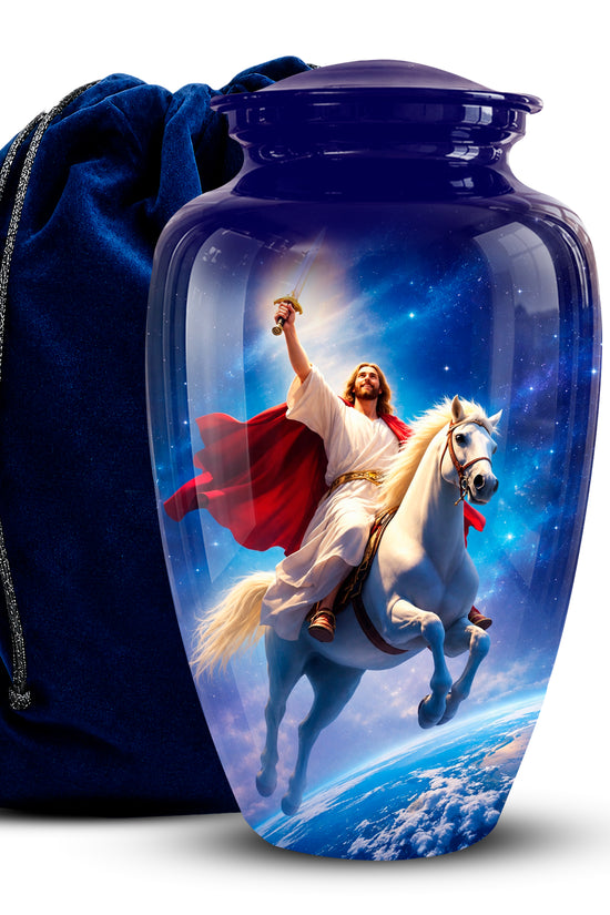 A glossy dark blue urn-shaped keepsake jar with a matching lid, shown in front of a dark blue velvet drawstring bag. The jar features a printed image of Jesus riding a white horse through a starry sky above Earth.