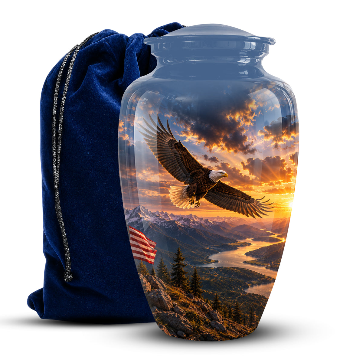 A glossy ceramic cremation urn with a lid, featuring a printed scenic design of a bald eagle flying over mountains and a river at sunset, shown next to a dark blue velvet drawstring bag on a white background.