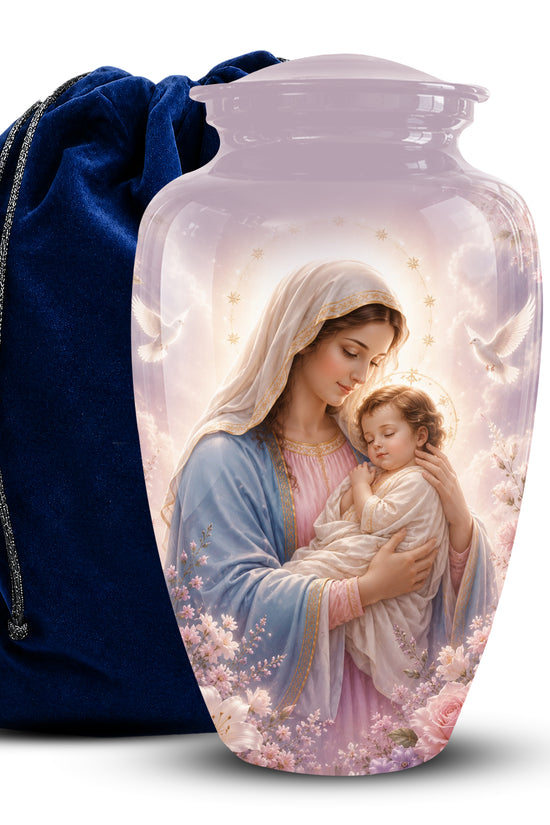 A glossy glass cremation urn featuring a printed devotional image of the Virgin Mary holding the infant Jesus, shown next to a dark blue velvet drawstring bag on a white background.