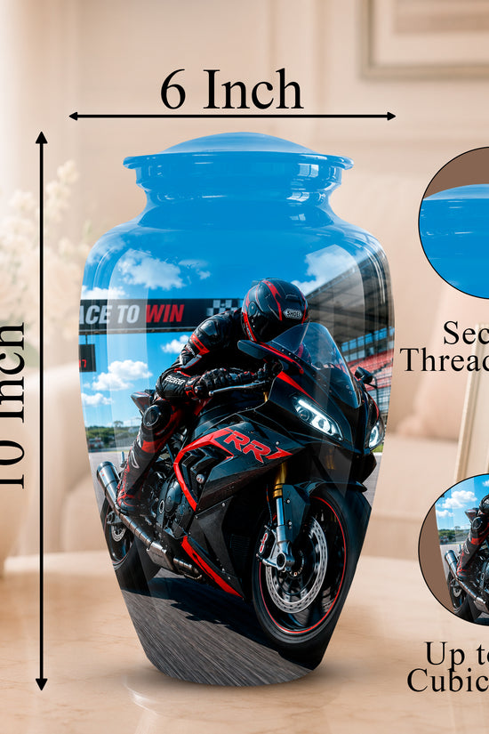 A printed ceramic or glass urn shaped like a blue motorcycle-themed jar, shown with dimension labels reading 6 Inch across the top and 10 Inch tall on the left. The jar features a printed motorcycle racer and bike design, with circular inset close-ups and text noting 'Secure Threaded Lid' and 'Up to 200 Cubic Inches.