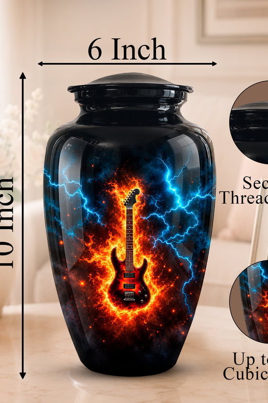 A black ceramic urn with a glossy finish, featuring a vibrant graphic of a red electric guitar surrounded by blue lightning and orange flames. The image includes dimension markers showing the urn is 10 inches tall and 6 inches wide, with circular insets showing the secure threaded lid and the detailed print texture.