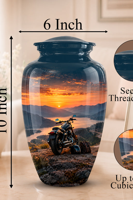A 10-inch by 6-inch ceramic memorial urn with a printed motorcycle landscape sunset design, shown on a tabletop with dimension callouts and feature callouts.