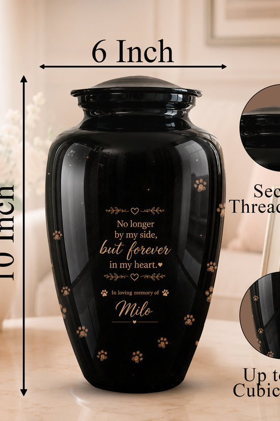 Black ceramic cremation urn with gold text and paw print designs, shown with dimension arrows indicating 10 inch height and 6 inch width. Includes inset circles showing the secure threaded lid and engraved design detail.