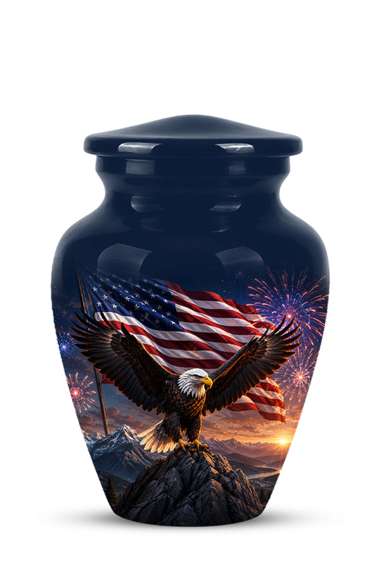 A glossy dark blue urn with a lid, featuring a printed graphic of a bald eagle on a mountain peak with an American flag, mountains, and fireworks in the background.