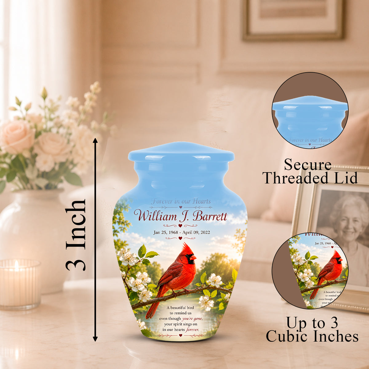 Personalized ceramic urn with a blue lid and a printed design of a red cardinal on white blossoms, shown on a tabletop with dimension callouts and circular inset details about the secure threaded lid and cubic capacity.