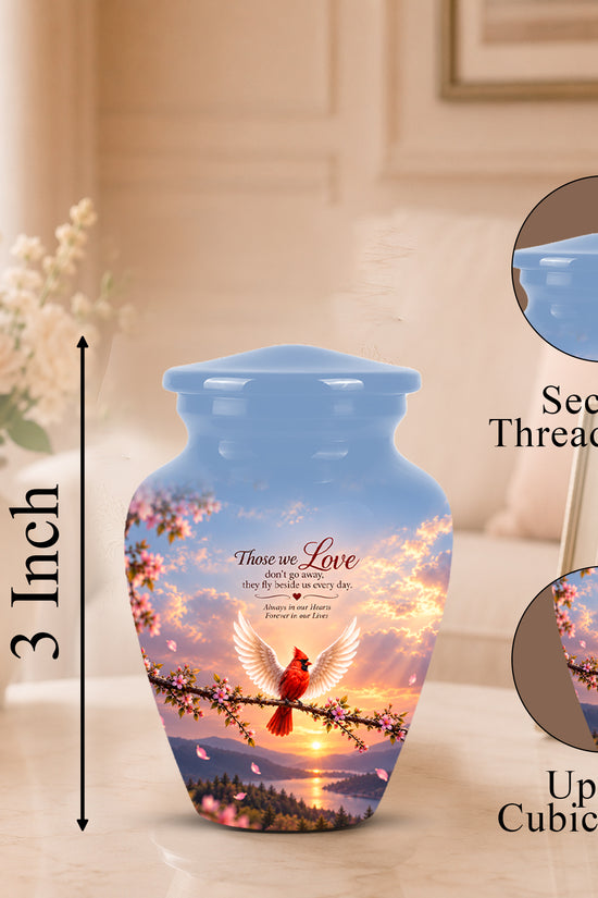 Personalized ceramic cremation urn with a blue sky and sunset design, featuring a red cardinal and cherry blossoms, shown on a tabletop with dimension and feature callout graphics.