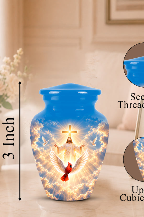 A blue cremation urn with a glowing religious design of Jesus, doves, and a red cardinal, shown on a tabletop with size and feature callouts. The image includes a 3-inch height marker, a secure threaded lid inset, and a 3 cubic inch capacity inset.