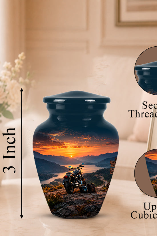A dark blue urn-shaped memorial vase with a scenic sunset landscape print on the front, shown on a tabletop with a blurred home interior background. A vertical arrow labels the height as 3 Inch, and two circular inset callouts show the secure threaded lid and up to 3 cubic inch capacity.