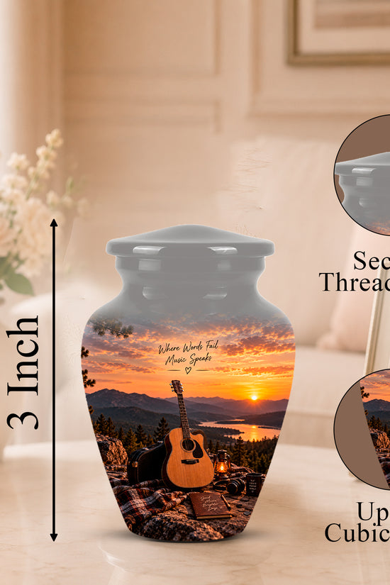 Personalized ceramic urn with a sunset landscape print featuring an acoustic guitar and mountains, shown on a tabletop with a 3-inch height marker, closed inset views of the threaded lid, and a framed photo in a softly lit room.