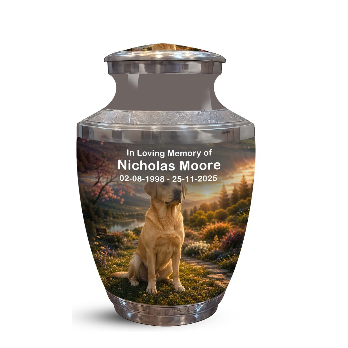 A memorial urn with a printed photo of a golden retriever dog sitting in a scenic landscape, with custom text reading 'In Loving Memory of Nicholas Moore' and dates. The urn has a brushed silver metallic finish and is shown on a plain white background.