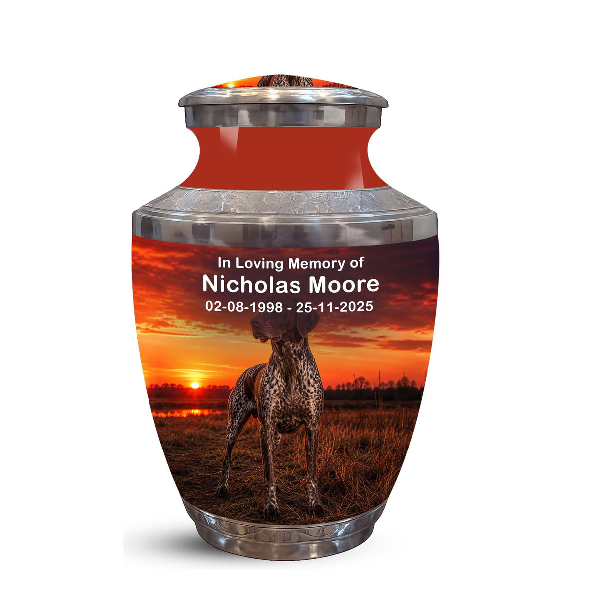 A memorial urn with a glossy red neck and silver metallic top and base, featuring a printed photo of a greyhound dog at sunset with personalized text reading 'In Loving Memory of Nicholas Moore' and dates.