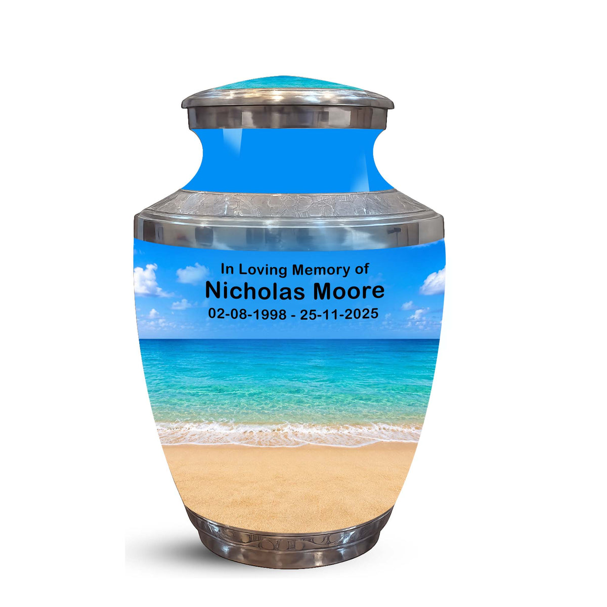 A memorial urn with a tropical beach print, featuring a blue sky and ocean design with custom text reading 'In Loving Memory of Nicholas Moore' and dates, set against a plain white background.