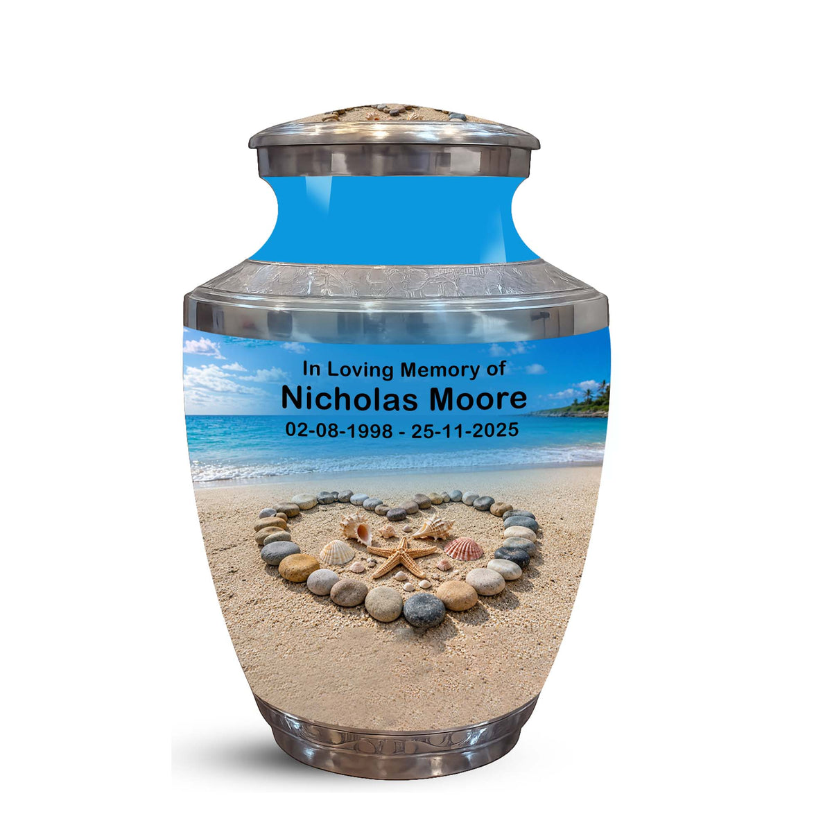 A memorial urn with a lid, featuring a custom printed beach scene on the front. The text on the urn reads 'In Loving Memory of Nicholas Moore 02-08-1998 - 25-11-2025'.