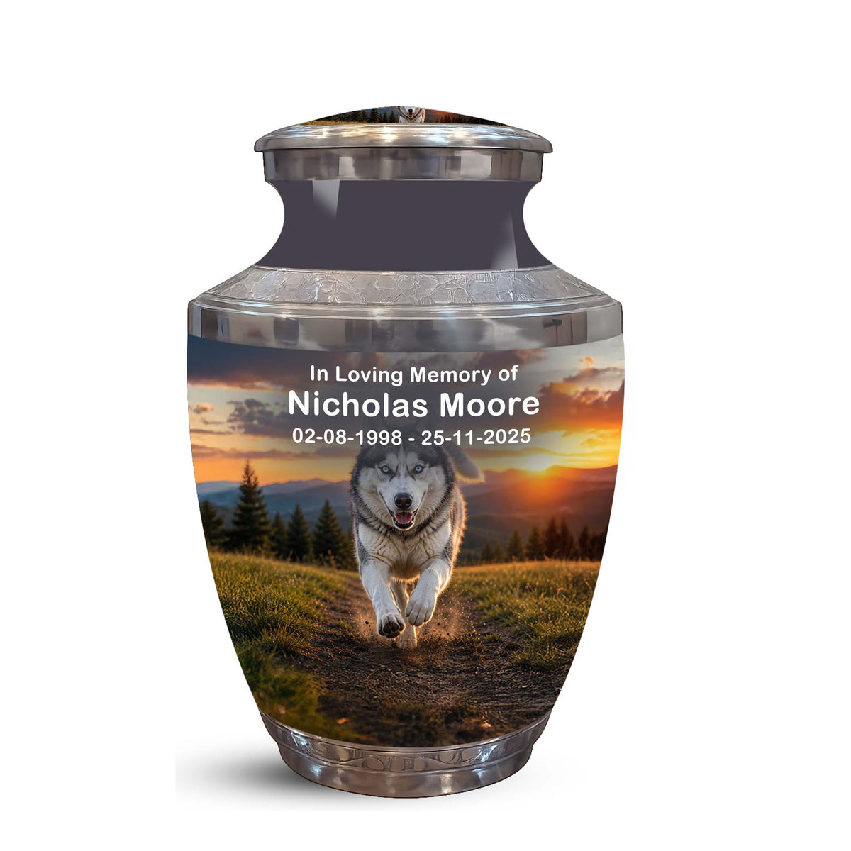 A memorial urn with a lid, featuring a printed photo of a husky running across a grassy field at sunset, with customizable text reading 'In Loving Memory of Nicholas Moore' and dates. The urn has a brushed silver metallic finish and is shown on a plain white background.