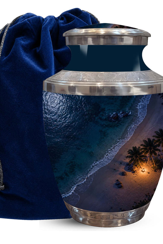 A ceramic urn featuring a tropical beach sunset print, shown next to a dark blue velvet drawstring bag on a white background.