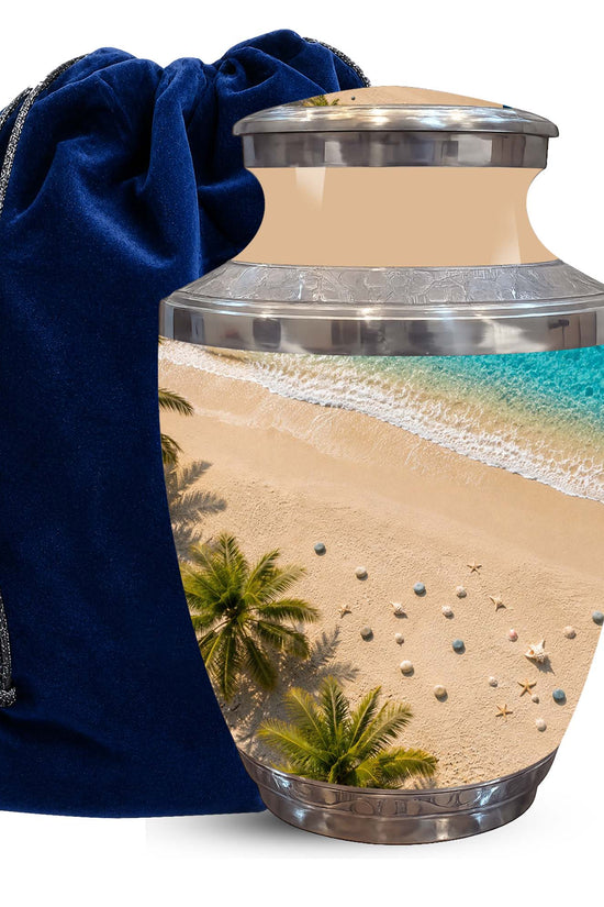 A ceramic cremation urn with a tropical beach print, shown next to a dark blue velvet drawstring bag on a white background.