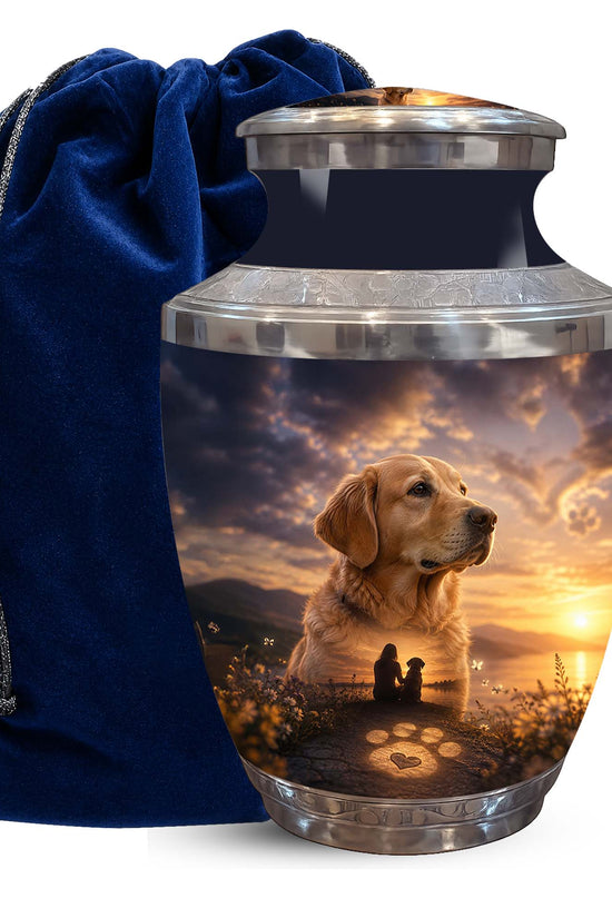 A memorial pet urn with a custom printed photo of a golden retriever and a sunset scene, shown next to a dark blue velvet drawstring bag on a white background.