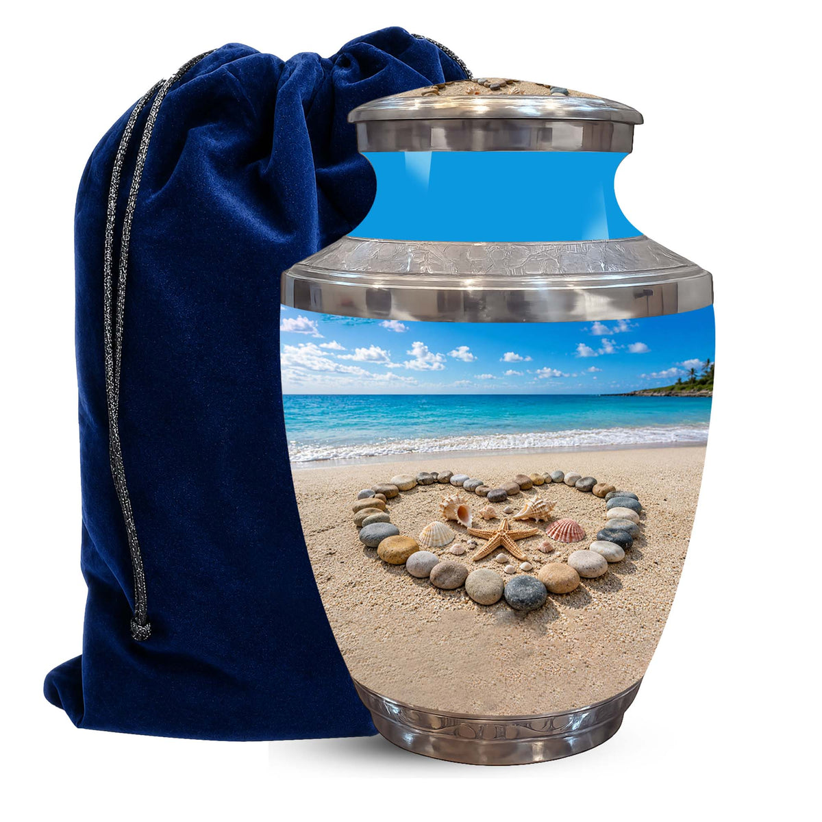 A ceramic urn with a stainless steel lid and base, featuring a printed beach scene with a heart-shaped arrangement of seashells and starfish on the sand. A dark blue velvet drawstring bag is positioned behind the urn on a white background.
