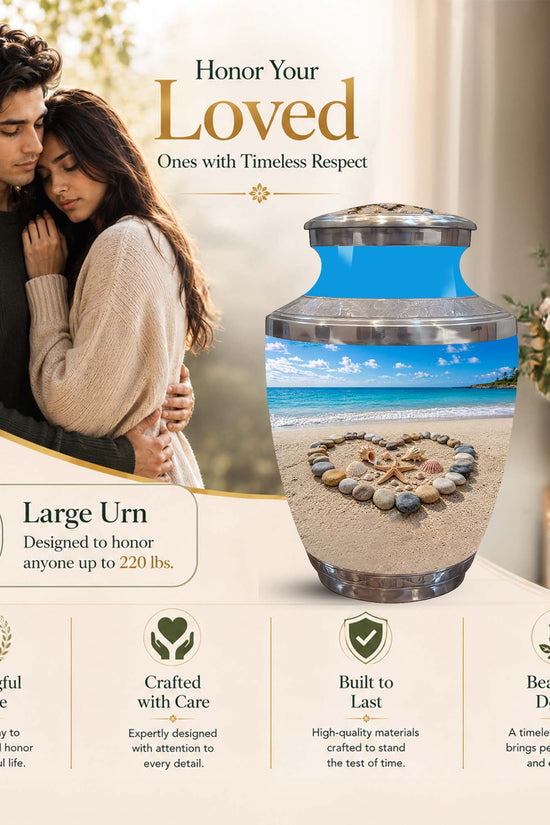 A large personalized urn displayed in a warm, elegant interior setting with a couple in the background. The urn features a blue top section and a lower section showing a printed beach scene with a stone circle.